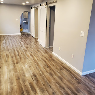 New LVP flooring installation with barn door hardware in a residential interior